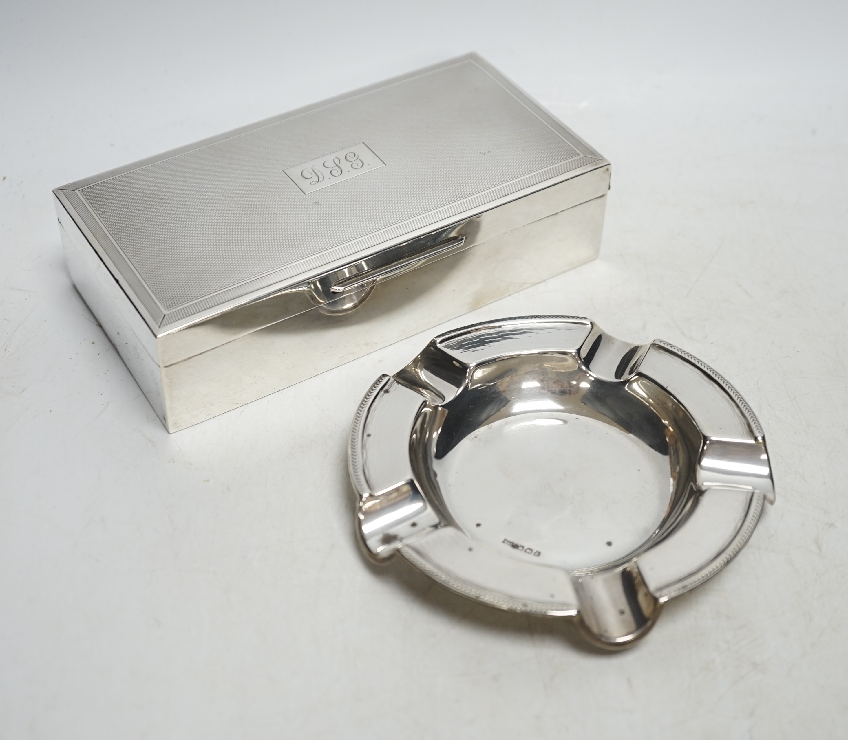 A 1960's engine-turned silver mounted rectangular cigarette box, 17.8cm and a silver ashtray. Condition - fair